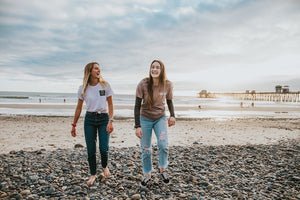 Young girls enjoy the beach with a nice walk while wearing their orange and blue Nöz nose sunscreen.